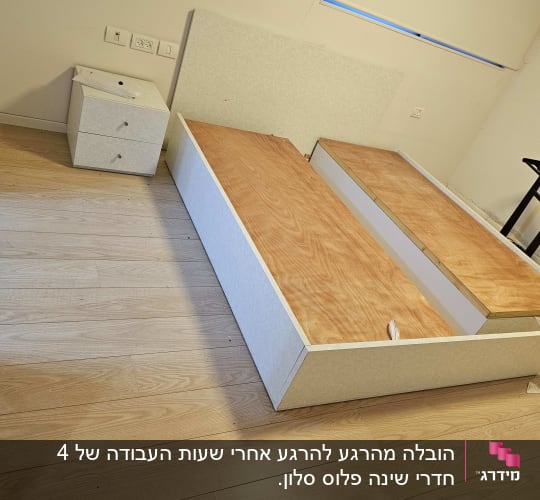 מיטה מפורקת וחלקי ריהוט על רצפת עץ